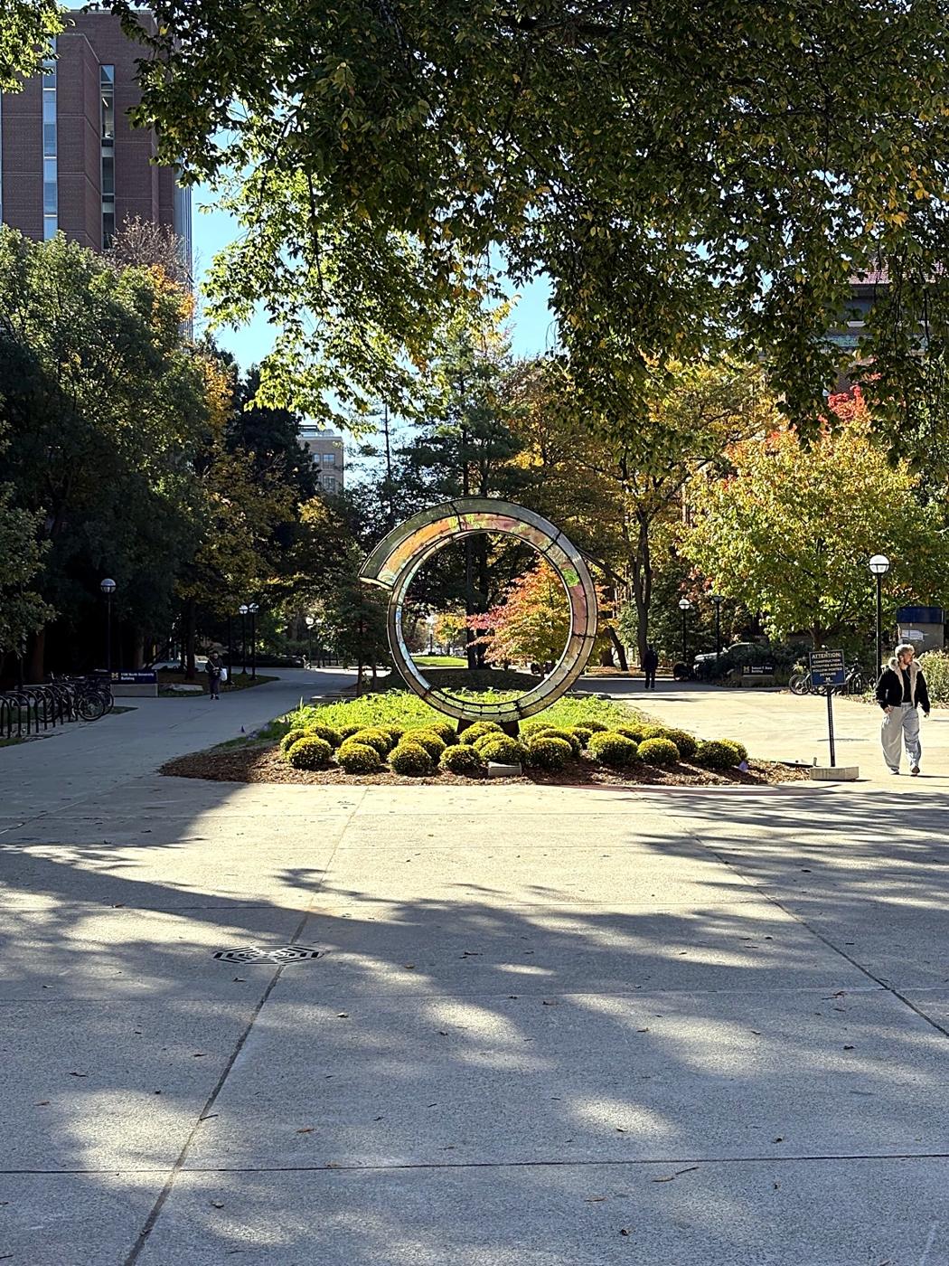 The circle sculpture and fall trees on the University of Michigan campus