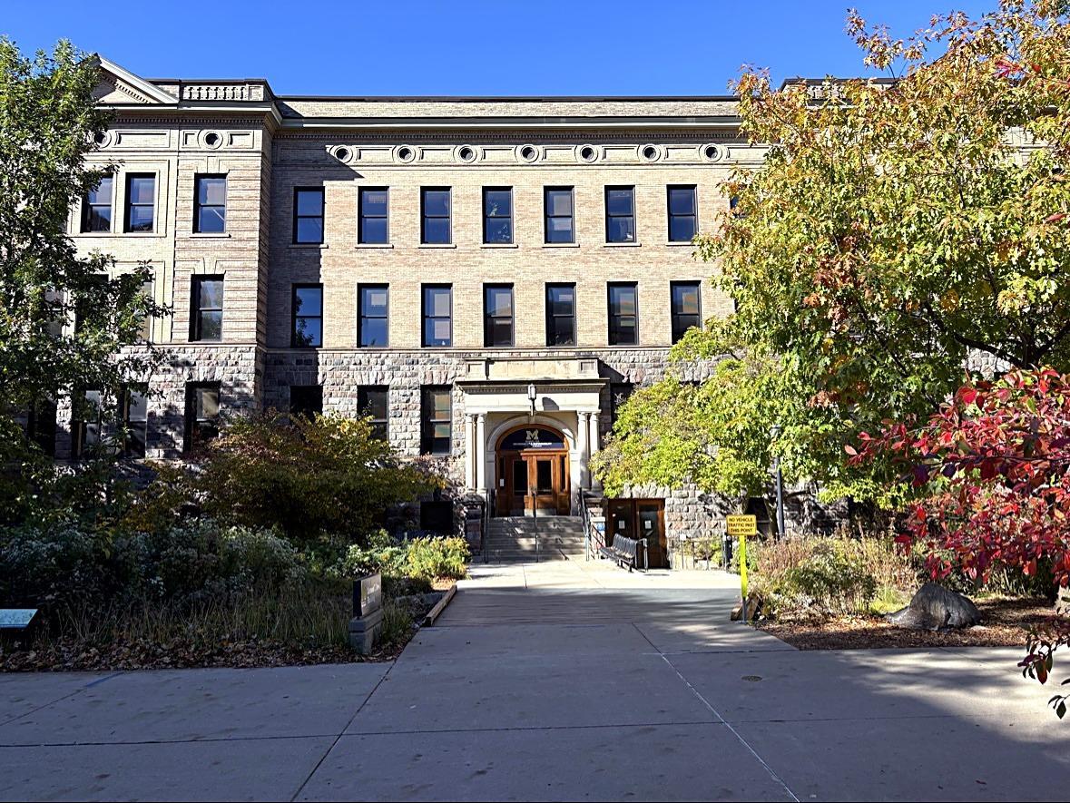 A stone University of Michigan building with a block M over the entrance