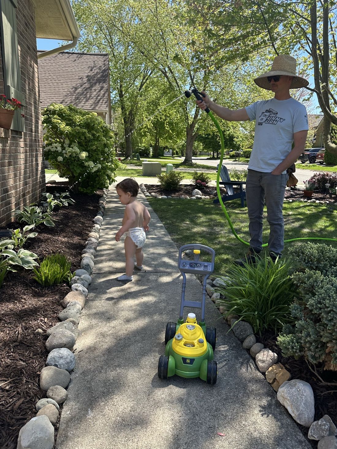 Watering the garden while Easton mows