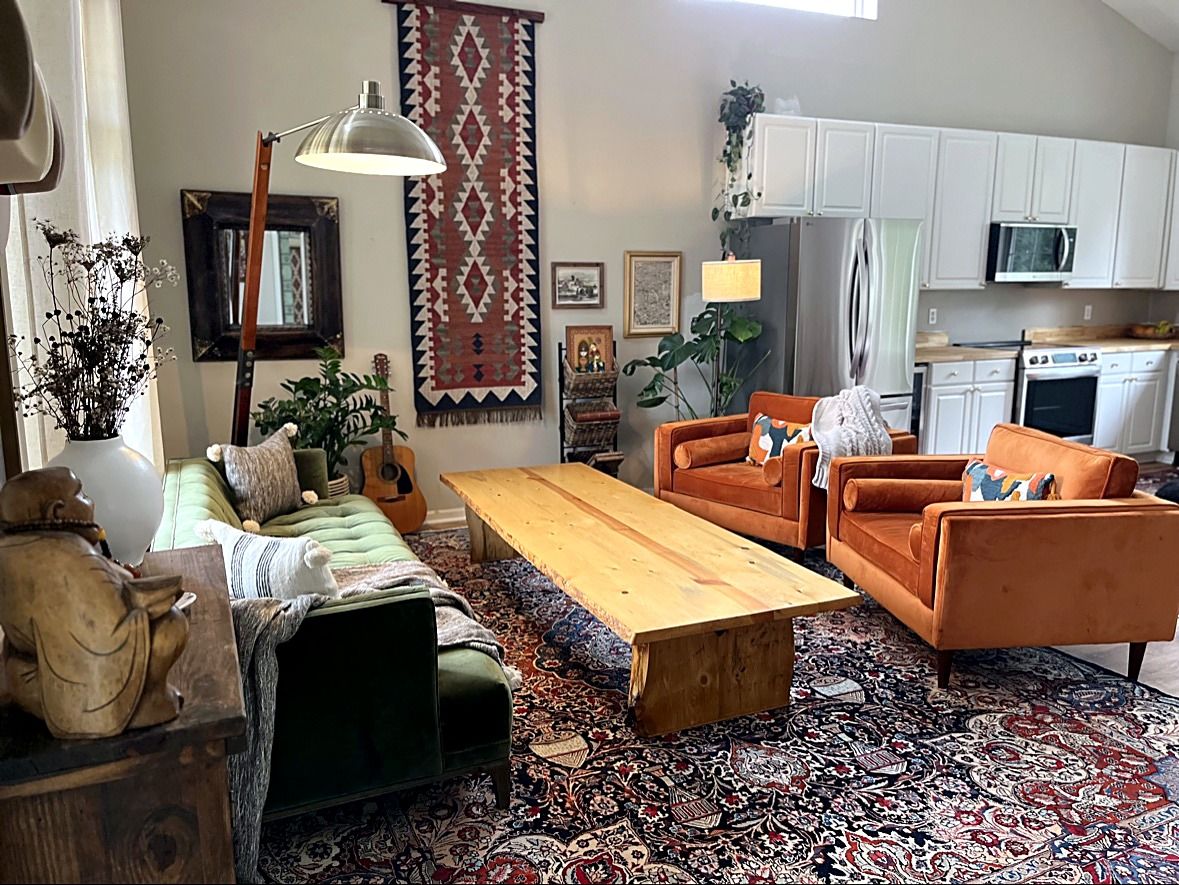 Kristian's family living room, with orange chairs, a green sofa, and a wood-slab coffee table