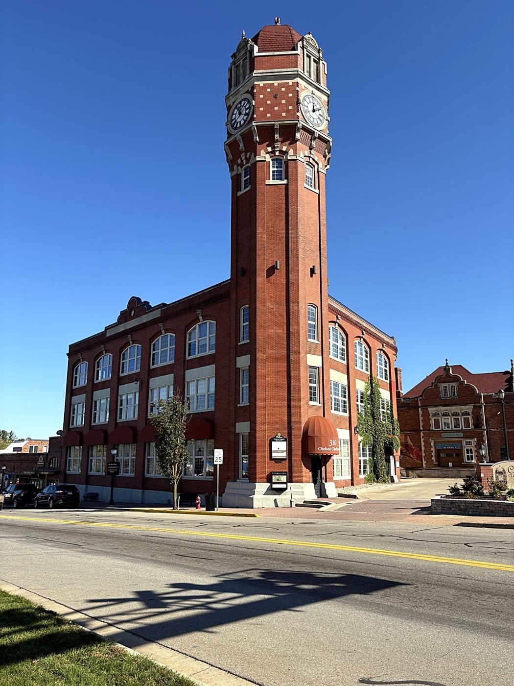 The brick clock tower in downtown Chelsea against a clear blue sky