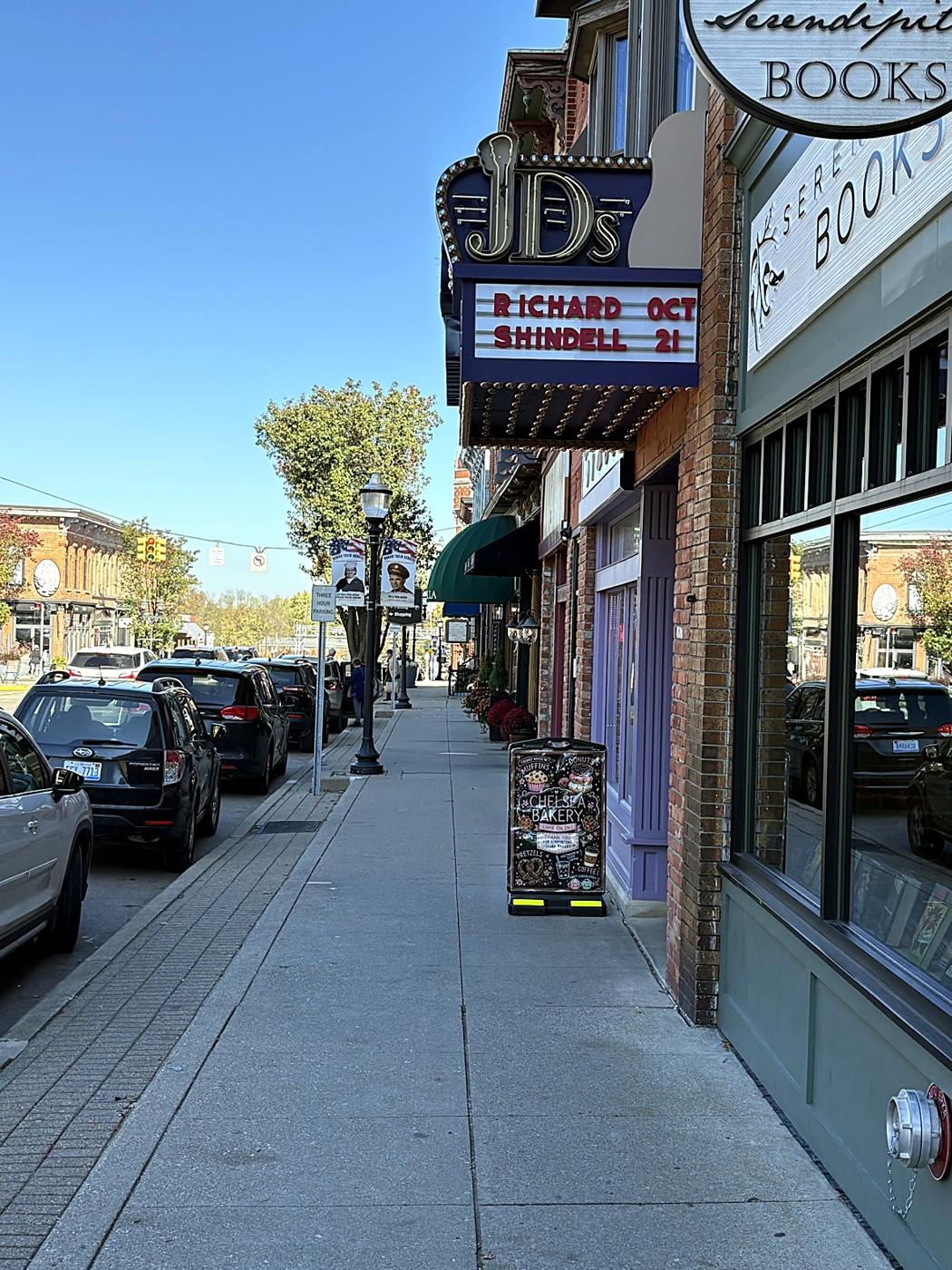 The Main Street sidewalk with a theater marquee and Serendipity Books
