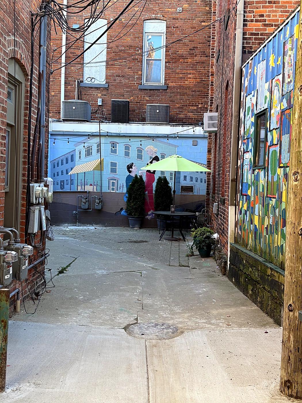 A painted mural and patio tucked into a downtown alley