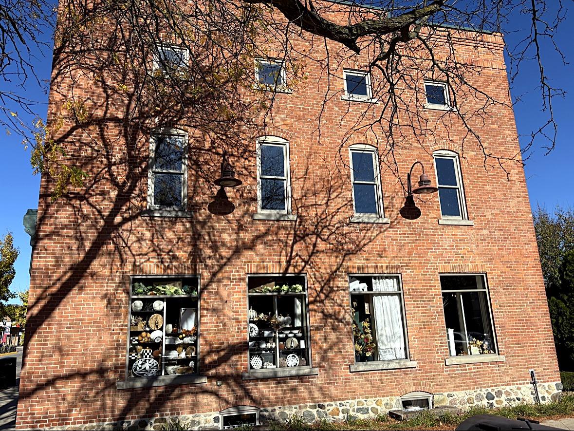 A brick building with a pottery shop in the ground-floor windows
