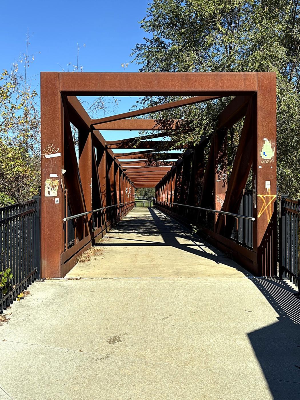 The rust-red Heritage Bridge, a truss footbridge over the Huron River in Ypsilanti